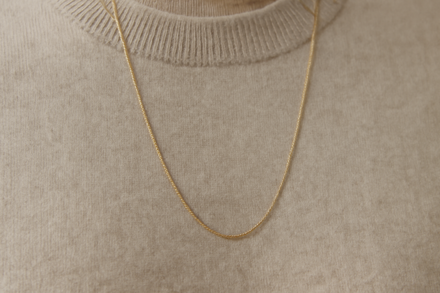 magasindemode-accessoire-minimaliste-tenue collier fin posé sur un pull sobre