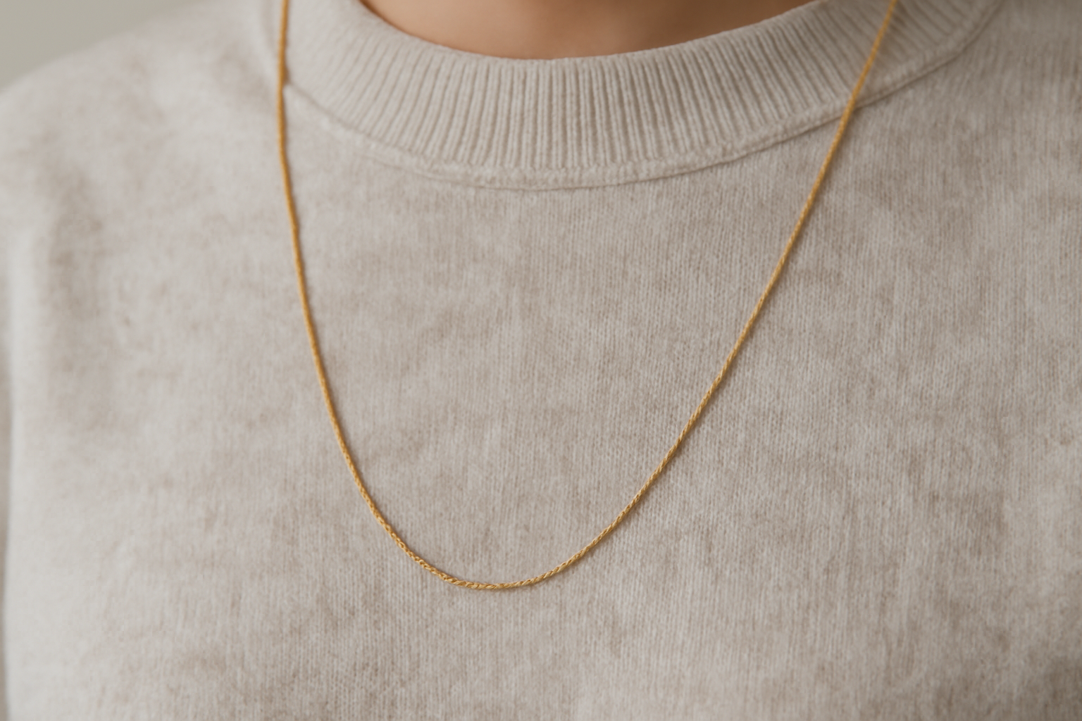 magasindemode-bijoux-minimalistes-tenue-monochrome collier fin posé sur pull monochrome