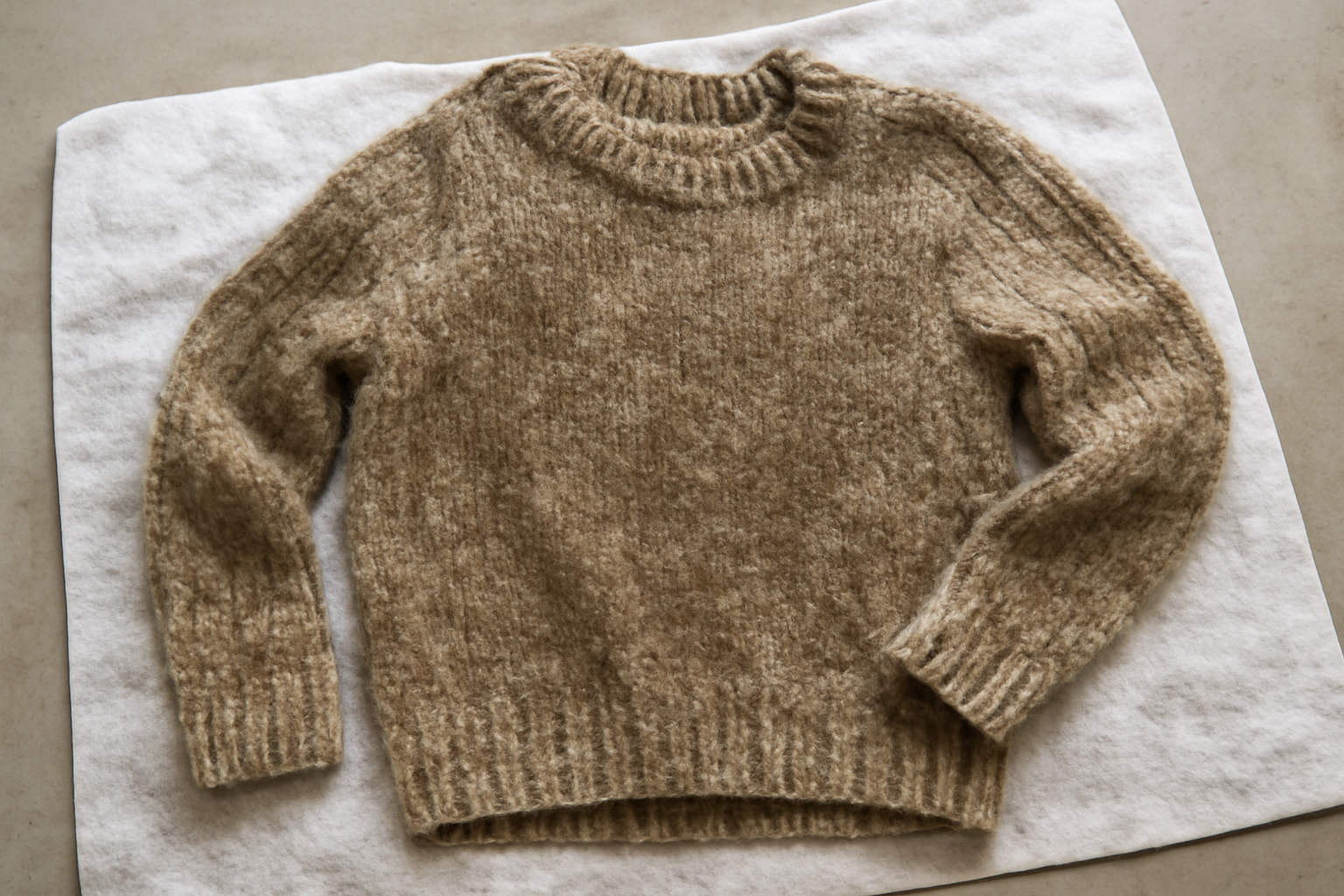 magasindemode-pulls-retrecissent-lavage pull en laine humide posé sur serviette